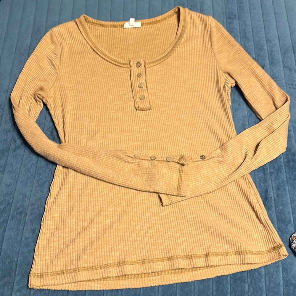 Ribbed long sleeve shirt with button details.